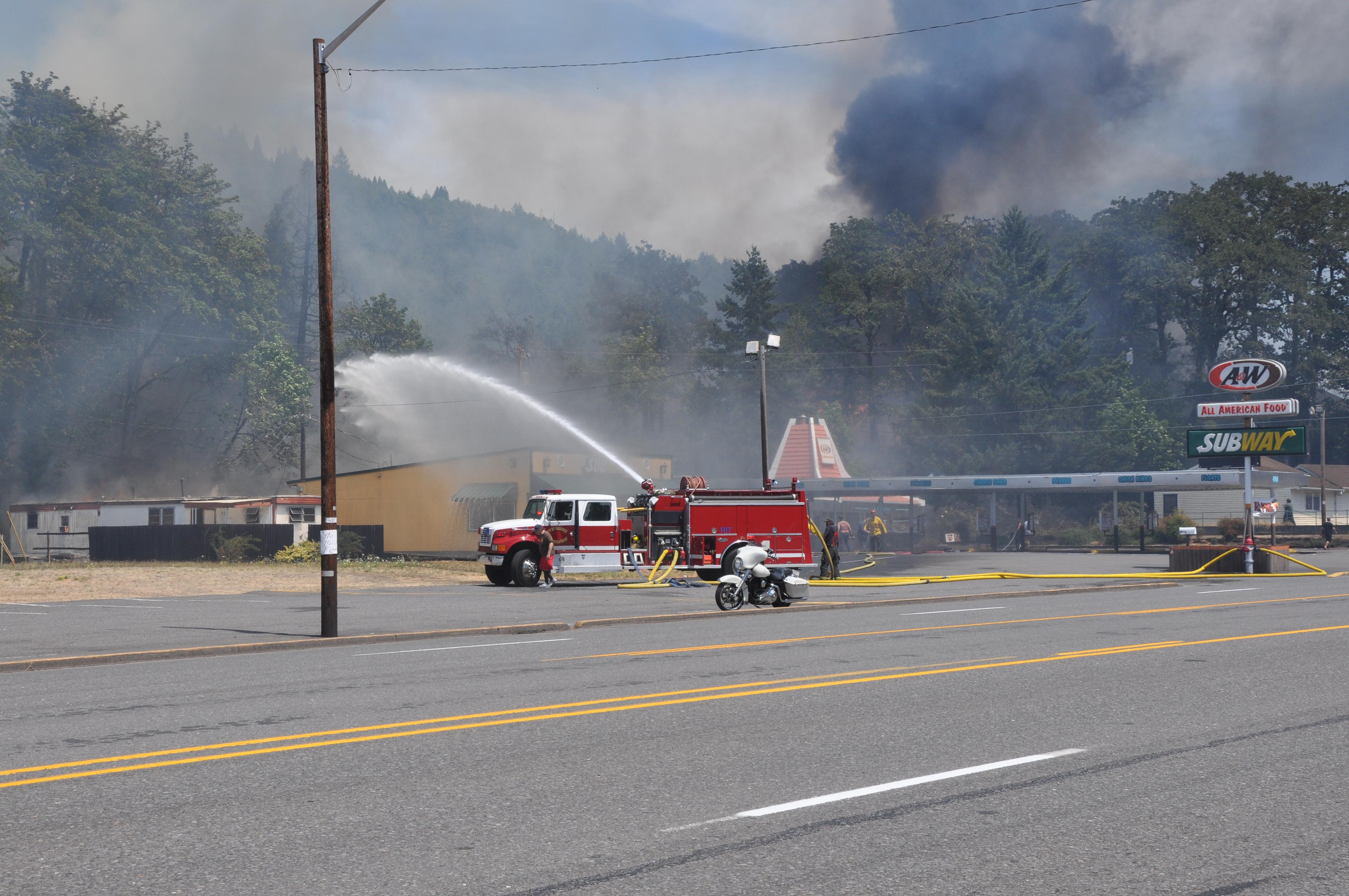 Woman faces flames with garden hose from roof of her business in Oakridge, Oregon KVAL